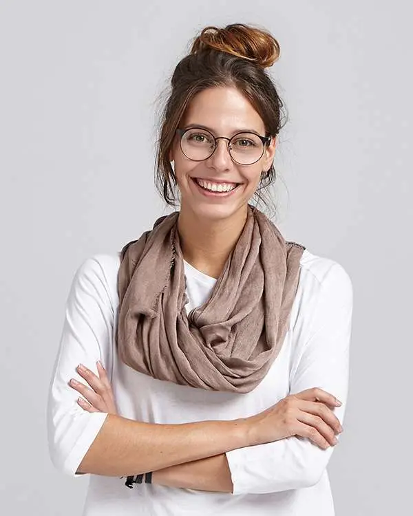 Woman smiling dressed in white tope on a grey background